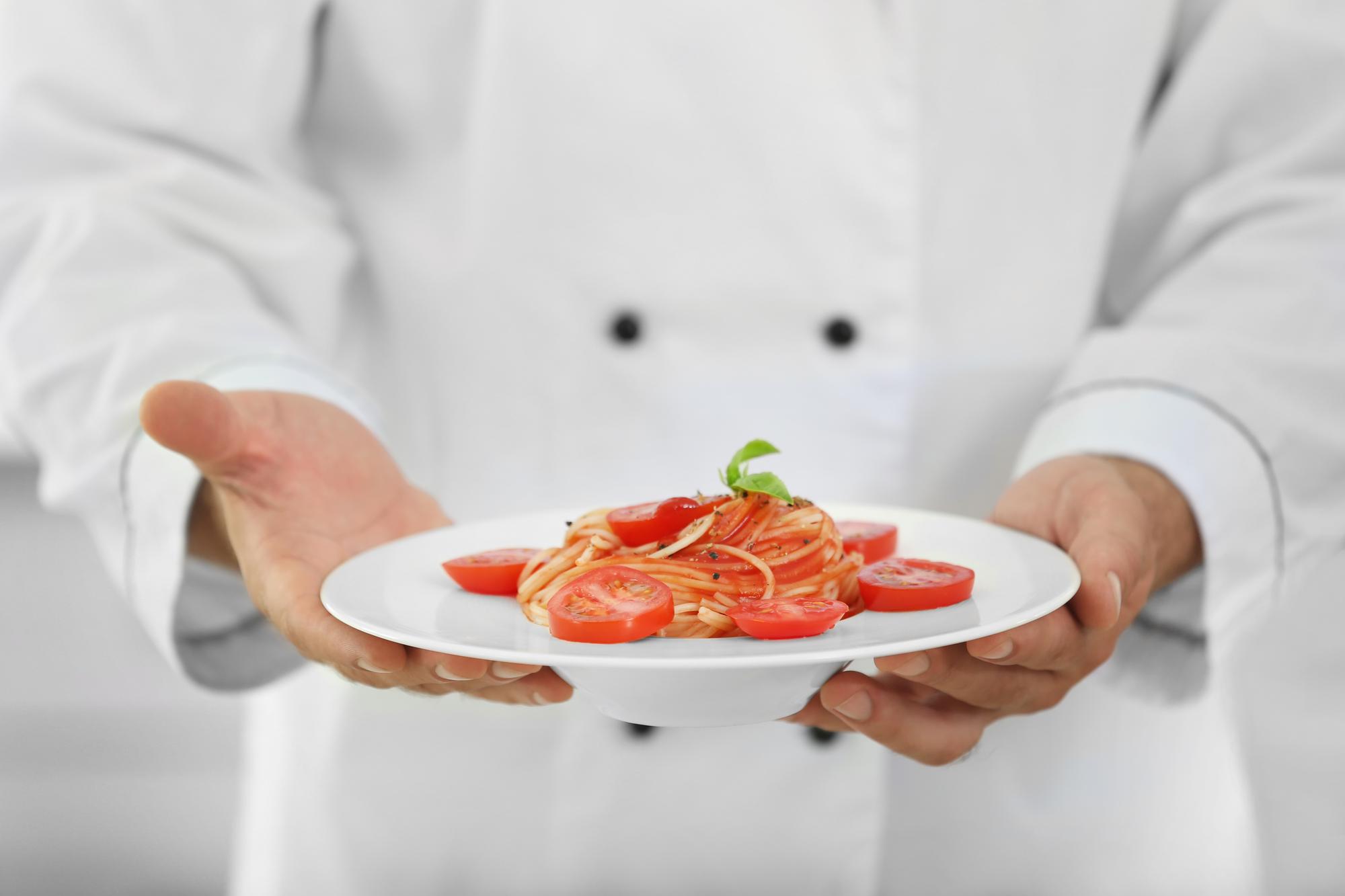 Chef hands plating in studio light